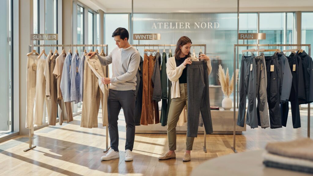 How to Choose Pants Fabric Based on Climate – shoppers comparing linen, cotton, wool, and weather-resistant pants fabrics for summer, winter, and rainy weather conditions.